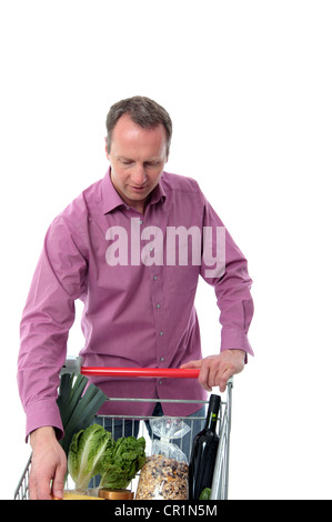 Reifer Mann tun einkaufen Laden seine Einkäufe auf einem Wagen isoliert auf weiss Stockfoto