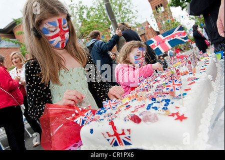 Kuchen, Wimpel, Gesicht malen und Champagner sind im ein Straßenfest in South West London trotz der ungeraden Platzen der Regen. Stockfoto