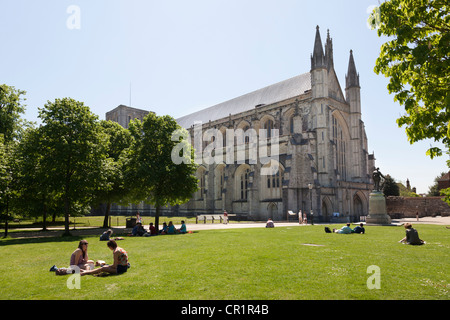 Menschen genießen die Sommersonne auf dem Gelände der Winchester Cathedral Stockfoto