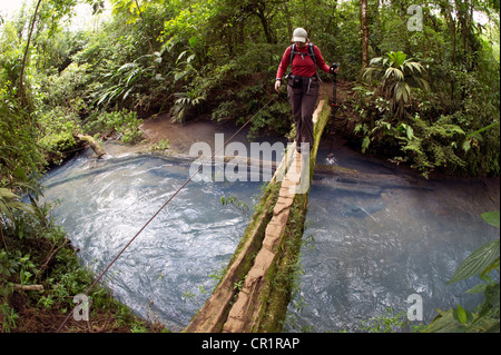 Wanderer, die Überquerung der Rio Celeste auf einer Holzbrücke, Tenorio Nationalpark Guanacaste, Costa Rica, Mittelamerika Stockfoto