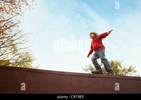 Junge, balancieren auf Holzwand Stockfoto