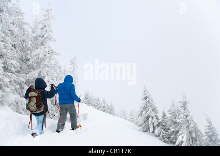 Vater und Sohn Schneeschuhwandern am Hang Stockfoto