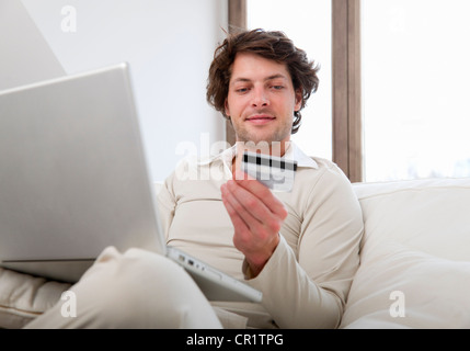 Mann, Online-shopping in Wohnzimmer Stockfoto