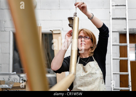 Frau tut Handarbeit in Werkstatt, England Stockfoto