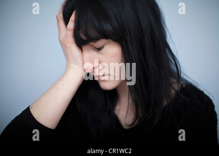 Nahaufnahme von Frau umklammert den Kopf Stockfoto