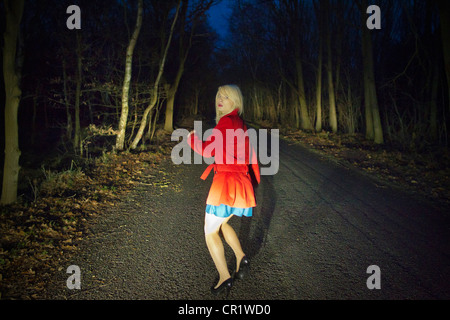 Frau läuft in der Angst im Wald bei Nacht Stockfoto