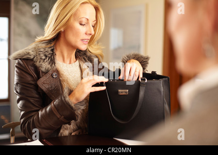 Frau beim Stöbern durch Geldbörse Stockfoto