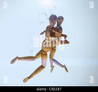 Holzfiguren in Wasser umarmen Stockfoto