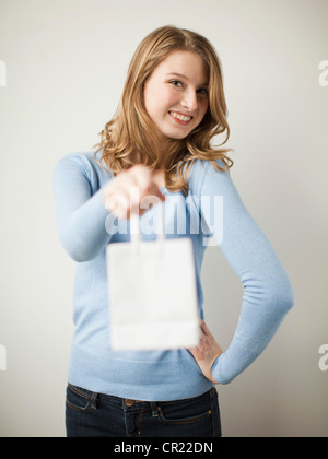 USA, Utah, Salt Lake City, Indoor Porträt Jungen glücklich Frau zeigt weiße präsentieren Tasche Stockfoto