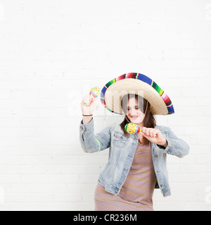 Studioaufnahme der jungen Frau tanzt im sombrero Stockfoto