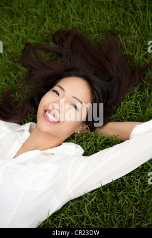 USA, Utah, Salt Lake City, erhöhte Ansicht der lächelnde Frau liegend auf Rasen Stockfoto