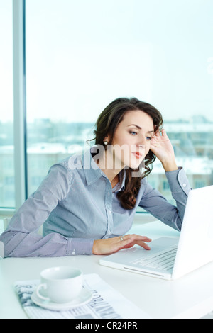 Geschäft Mädchen nachdenklich mit Blick auf den Laptop-Bildschirm Stockfoto