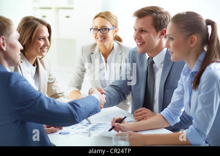 Partner Geschäft abzuschließen und Händeschütteln im Beisein von Teammitgliedern Stockfoto