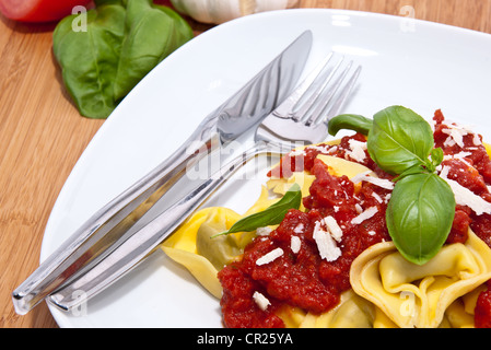 Frische Tortellini mit Tomatensauce auf hölzernen Hintergrund Stockfoto