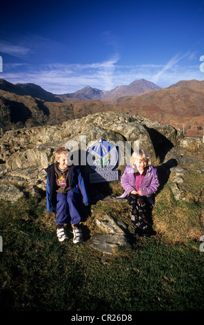 England, Wales, Snowdonia-Nationalpark, mit Kindern posieren für ein Foto vor der Grenze Parkschild. Stockfoto