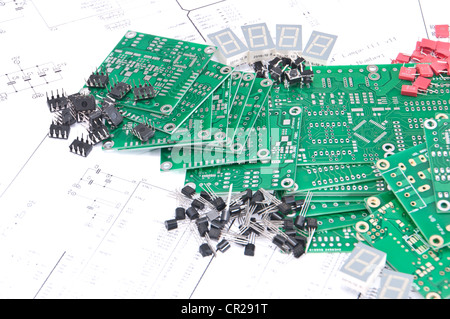 Leiterplatten und elektronische Bauteile mit Schaltplänen im Hintergrund Stockfoto