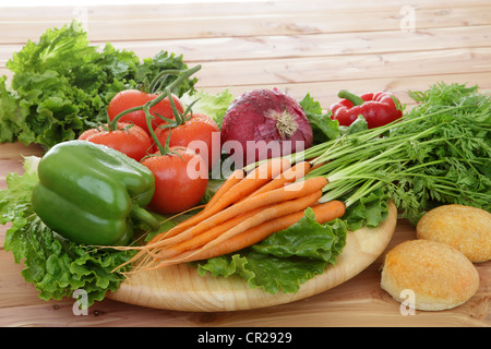 Bio-Gemüse in rustikaler Umgebung einschließlich Tomaten auf der Rebe, Paprika, Karotten, Kopfsalat. Stockfoto