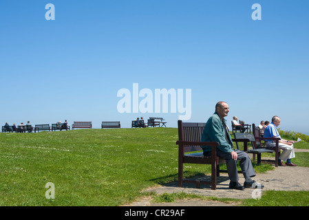 Leute auf den Bänken an der Spanisch-Batterie, Tynemouth. Stockfoto