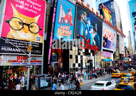 Legendären New York gelbe Taxis auf dem Times Square in Manhattan. Werbeschilder für Shows über Disney Store Times Square in New York Stockfoto