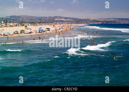 Genießen Sommer Strandbesucher und Schwimmer die pazifischen Ozeans Brandung entlang der Balboa Peninsula in Newport Beach in Süd-Kalifornien, USA. Stockfoto