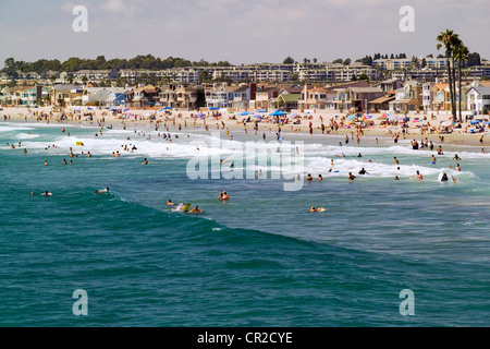 Genießen Sommer Strandbesucher und Schwimmer die pazifischen Ozeans Brandung entlang der Balboa Peninsula in Newport Beach in Süd-Kalifornien, USA. Stockfoto