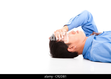Geschäftsmann am Boden liegend mit Kopfschmerzen Stockfoto