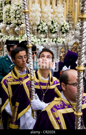 Mitglied der katholischen Kirche Gleitkommazahl Verarbeitung in Sevillas Semana Santa Ostern Heiligen Woche Prozession begleiten. Sevilla Spanien. Stockfoto