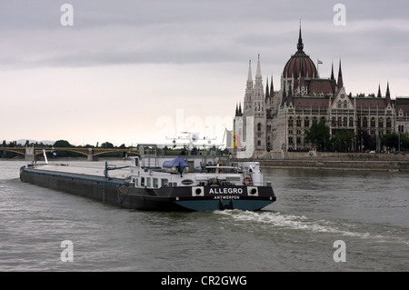 Lastkahn an der Donau, Budapest mit dem Parlamentsgebäude im Hintergrund. Stockfoto