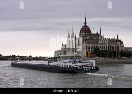 Lastkahn an der Donau, Budapest mit dem Parlamentsgebäude im Hintergrund. Stockfoto