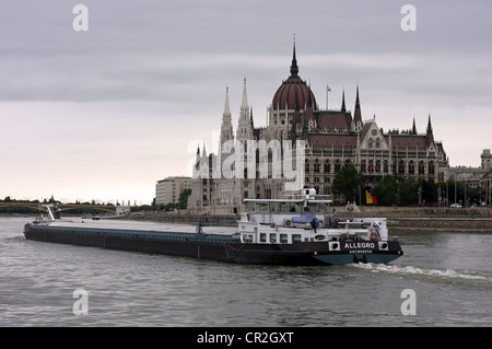 Lastkahn an der Donau, Budapest mit dem Parlamentsgebäude im Hintergrund. Stockfoto