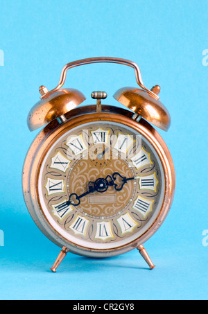 Retro Vintage Uhr mit römischen Zahlen auf blauen Hintergrund. Antike alte Objekt. Stockfoto
