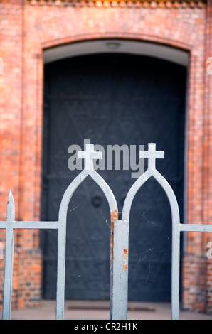 kirchliche Stahltor und Fragment der Eingang. religiöses Symbol Kreuz und Gebäude. Stockfoto