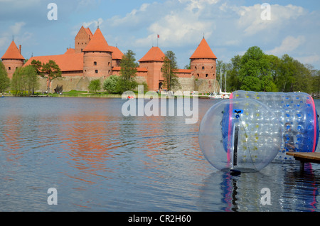 Zorbing Luftblasen auf dem Wasser. Trakai Burg, umgeben von See Galve. XIV - XV Jahrhundert Architektur in Litauen. Stockfoto