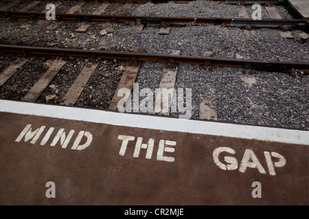 Rand der Bahn Bahnsteig mit bemalten Warnschild Stockfoto