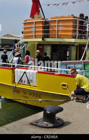 Crew-Mitglied wartet auf Passagiere an Bord Ausflugsboot Maid von Poole vor dem Verlassen des Kais und Überschrift auf Brownsea Island Stockfoto