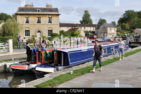 Zwei Narrowboats verhandeln Bradford auf Avon Schloss der Kennet und Avon Kanal, während eine Gruppe von interessierten Zuschauer blicken auf. Stockfoto