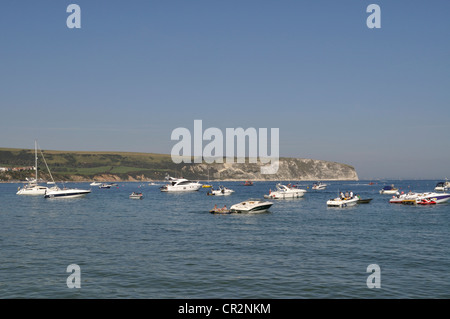 Boote vor Anker in der Bucht bei Swanage, Dorset, mit den Kreidefelsen von Ballard Down im Hintergrund. Stockfoto