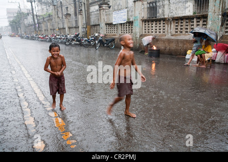 Cebu City, Philippinen, 11. März 2012: philippinische Kinder Spaß bei einem Regenguss während die Regenzeit zu Ende geht. Stockfoto