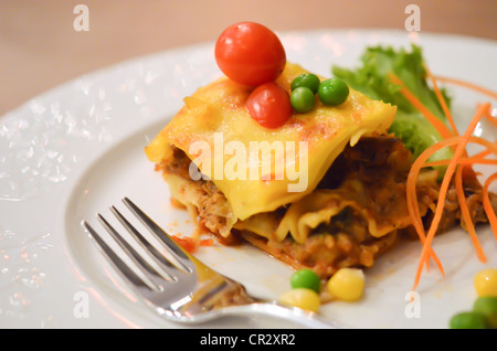 Rindfleisch-Lasagne, serviert mit Tomaten und frischem Gemüse Stockfoto