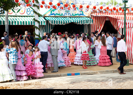 Junge Frauen und Mädchen tragen Flamenco-Kleider an die 'Feria de Abril' April Fair in Sevilla, Andalusien, Spanien, Europa Stockfoto