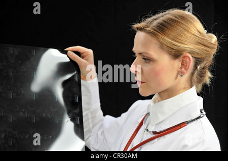 Assistenzärztin, junger Arzt eine Röntgenaufnahme zu betrachten Stockfoto