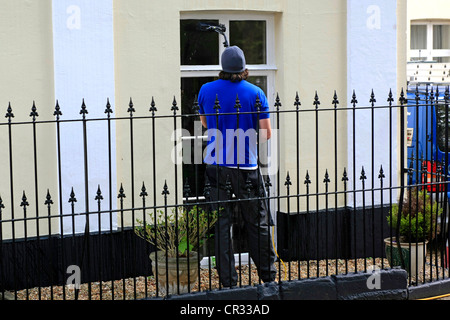 Ein Fenster Reiniger mit den neuen Extender Pol um saubere Fenster anstelle von Leitern und Stufen Stockfoto