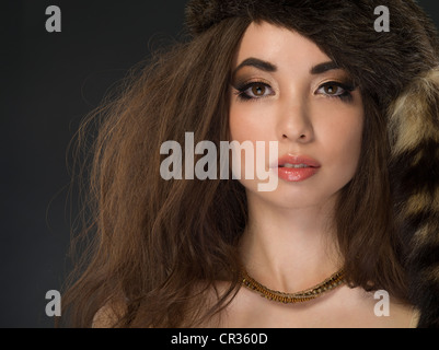 Studio-Porträt der schönen asiatisch-amerikanische Frau in ihren 20ern tragen faux Pelz Davy Crockett Coonskin Hut Stockfoto