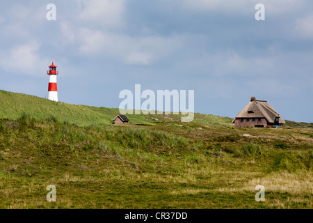 Rot-weiß gestreifte Leuchtturm der Liste Ost mit einem friesische Haus auf der Sylter Halbinsel Ellenbogen, Liste, Sylt, Nordfriesland Stockfoto