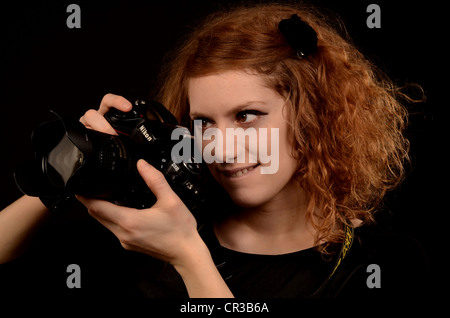 Rothaarige Frau, die mit einer Kamera fotografieren Stockfoto