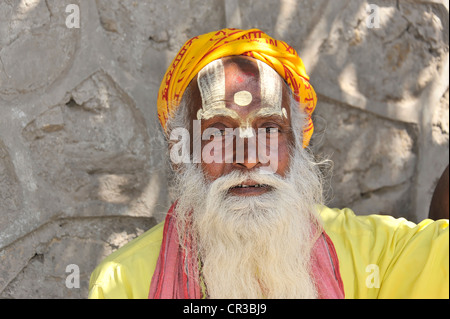 Sadhu heiliger Mann mit bunt bemalte Gesicht und Bart, Porträt, Hinduismus, Makkan Tole Vorplatz der Krishna-Tempel in Stockfoto