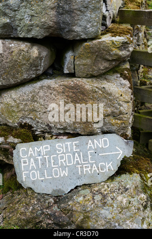 Campingplatz und Anfahrt Patterdale unterzeichnen auf Schiefer Steinmauer trocken fest. Stockfoto