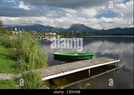 Ein Holzsteg und ein Boot auf See Hopfensee in der Nähe von Füssen, Allgäu, Bayern, Deutschland, Europa Stockfoto