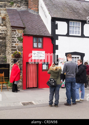 Das kleinste Haus in Großbritannien in Conwy Nord-Wales mit einer Frau-Keeper im walisischen Kleid und Touristen fotografieren Stockfoto