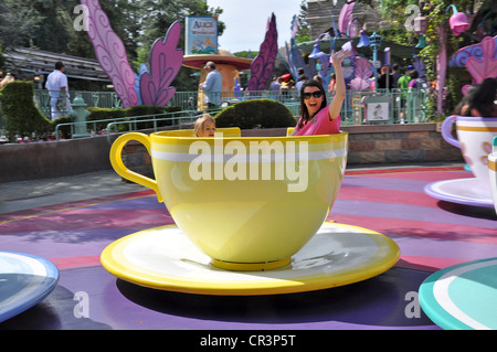 Familien, die Spaß beim Winken haben, während sie auf Disneyland's Tea Cups and Saucers Attraction in Fantasyland, Anaheim, CA, USA, fahren Stockfoto